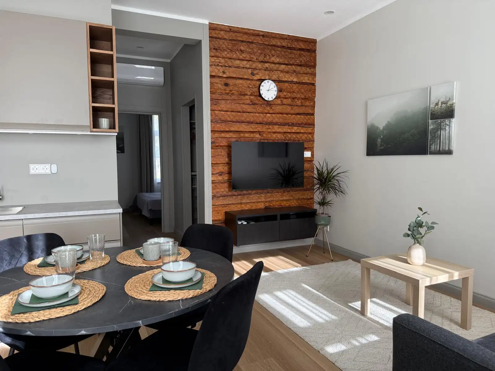 Renovated apartment living room and kitchen with a lacquered log wall