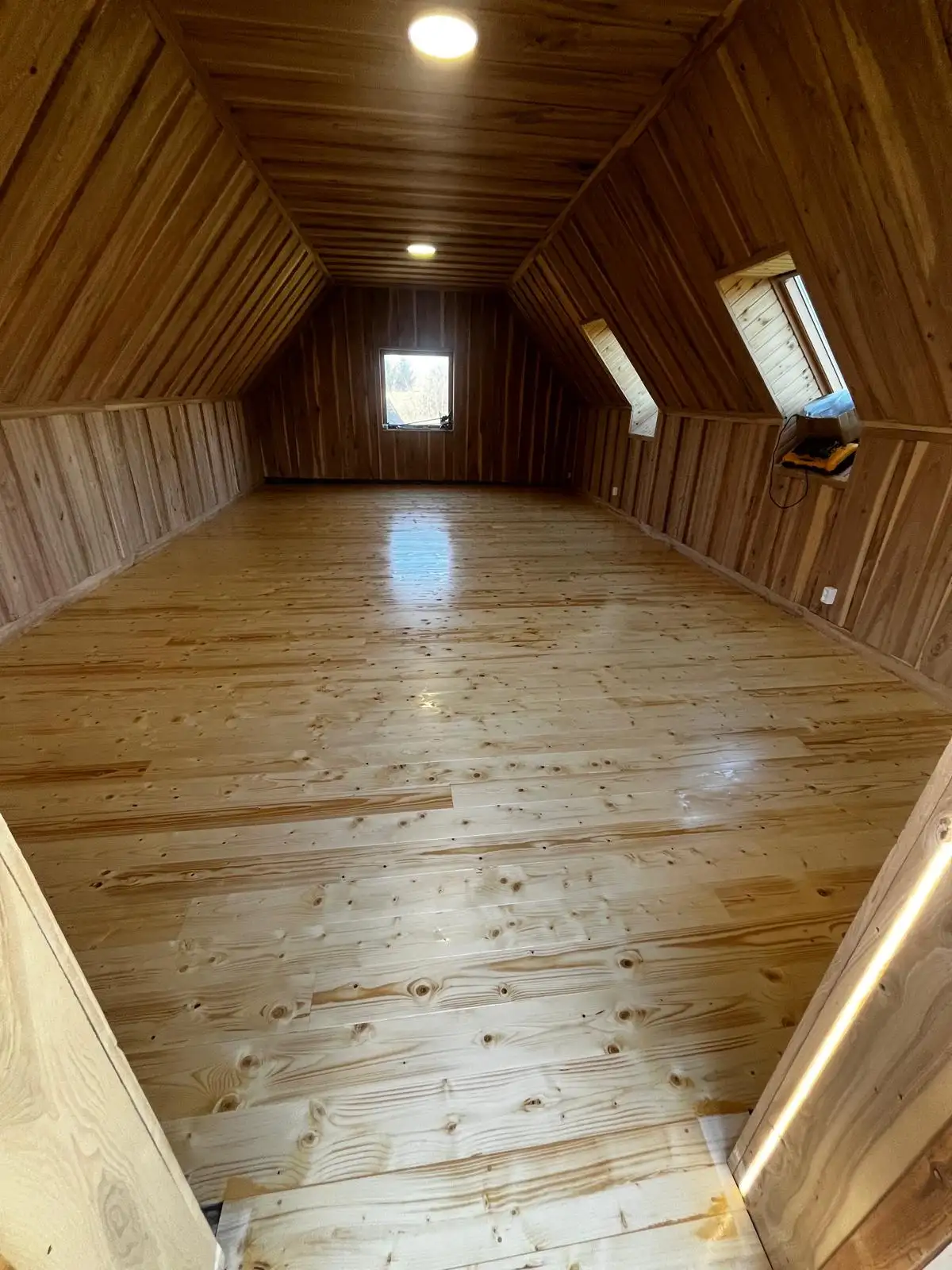 Attic room lined in ash boards with a lacquered pine floor